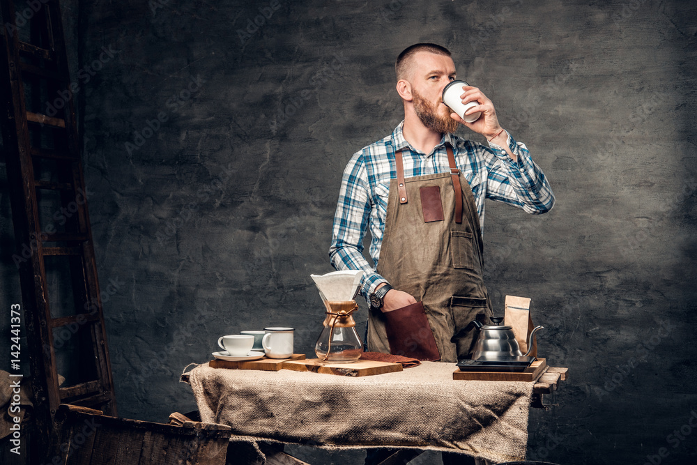A man at the table with automatic coffee machine. A man at the table with automatic coffee machine.