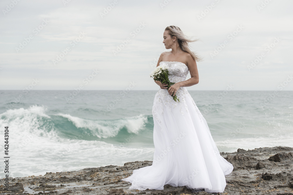 Beautiful bride at the beach with a flower bouquet. Beautiful bride at the beach with a flower bouquet.