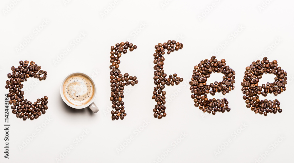 Top view of word coffee made from coffee beans and cup of hot coffee Top view of word coffee made from coffee beans and cup of hot coffee