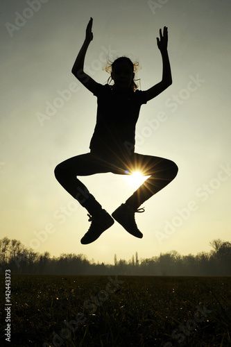 Silhouette of girl jumping. Backlit. Joy. Freedom