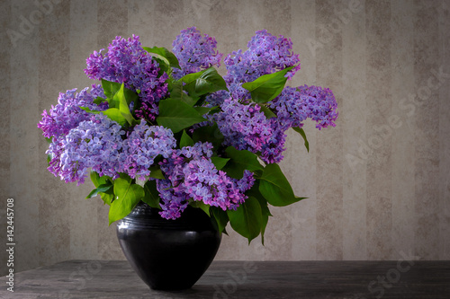 A bouquet of lilac in a black vase