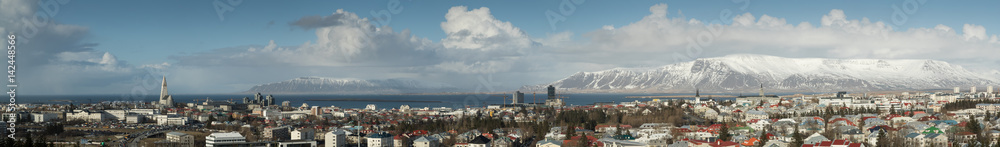 Panorama of Reykjavik skyline showing Hallgrimskirkja church cathedral and the mountains in the background.
