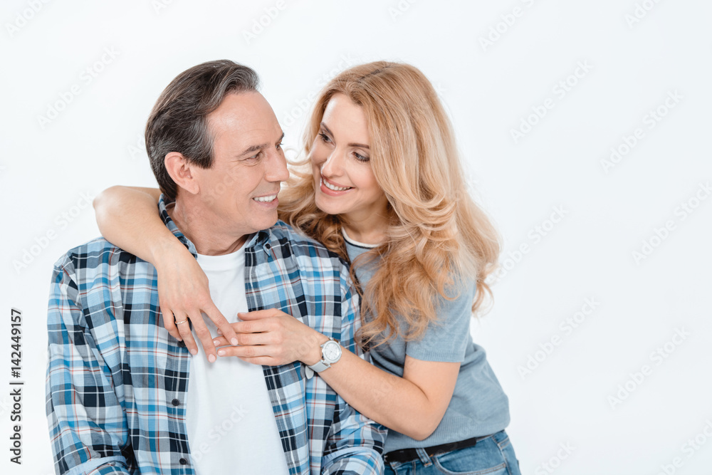 Front view of man and blonde woman embracing and smiling on white Front view of man and blonde woman embracing and smiling on white