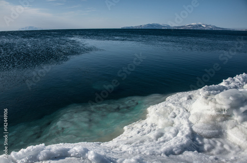 Ice coast and blue water of the Okhotsk Sea in winter photo