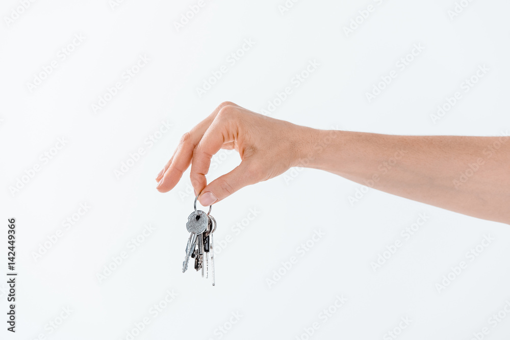 partial view of hand holding keys from new house on white partial view of hand holding keys from new house on white