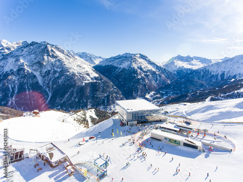 Skiing in the alps. Aerial view over the ski slope with ski lift and gondola visible