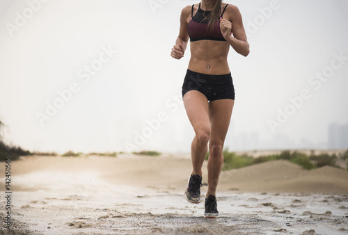 Foto Strong athletic woman wearing black short tights and sports top showing six pack
