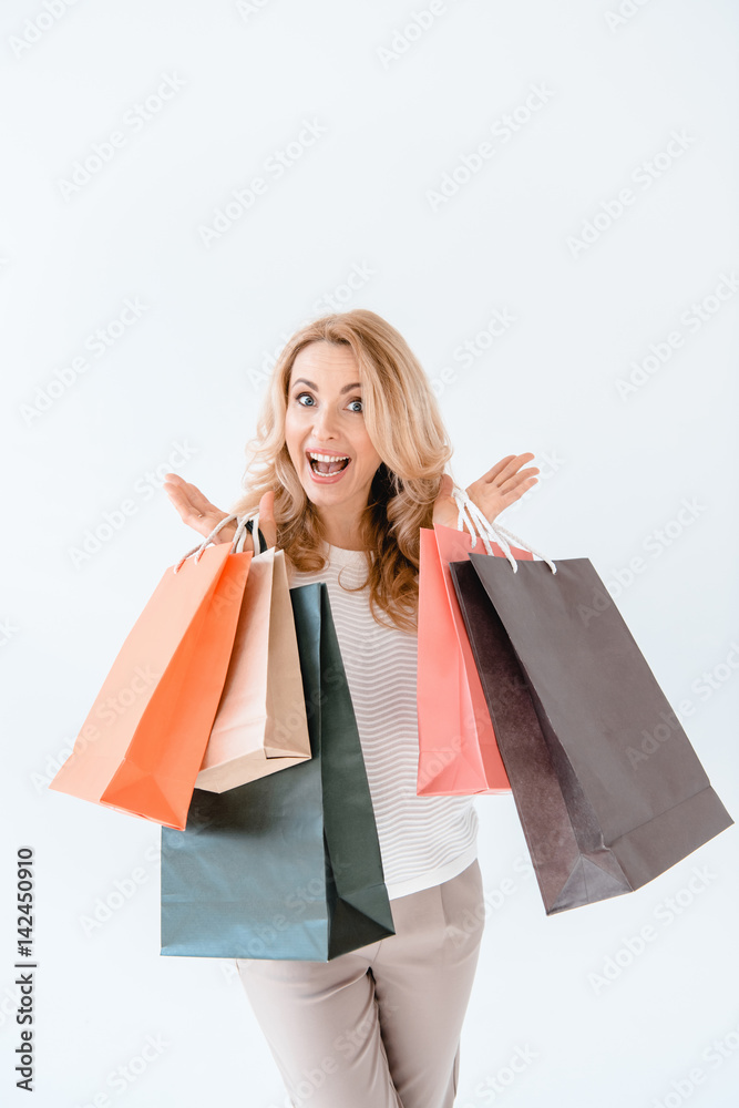 Surprised blonde woman holding shopping bags and looking at camera Surprised blonde woman holding shopping bags and looking at camera
