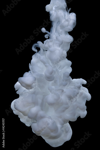 Explosion of white acrylic paint in water on black background.