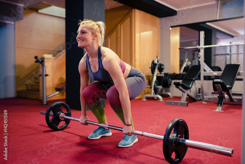 Blonde girl weight lifting at gym
