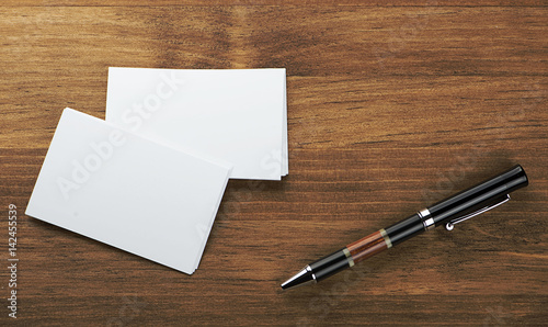 The business cards and the pen on the table. Horizontal studio shot.