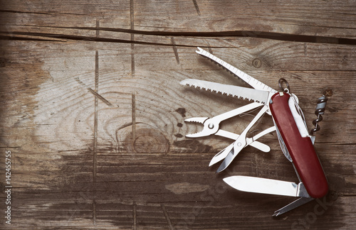 old Swiss knife on a wooden background photo