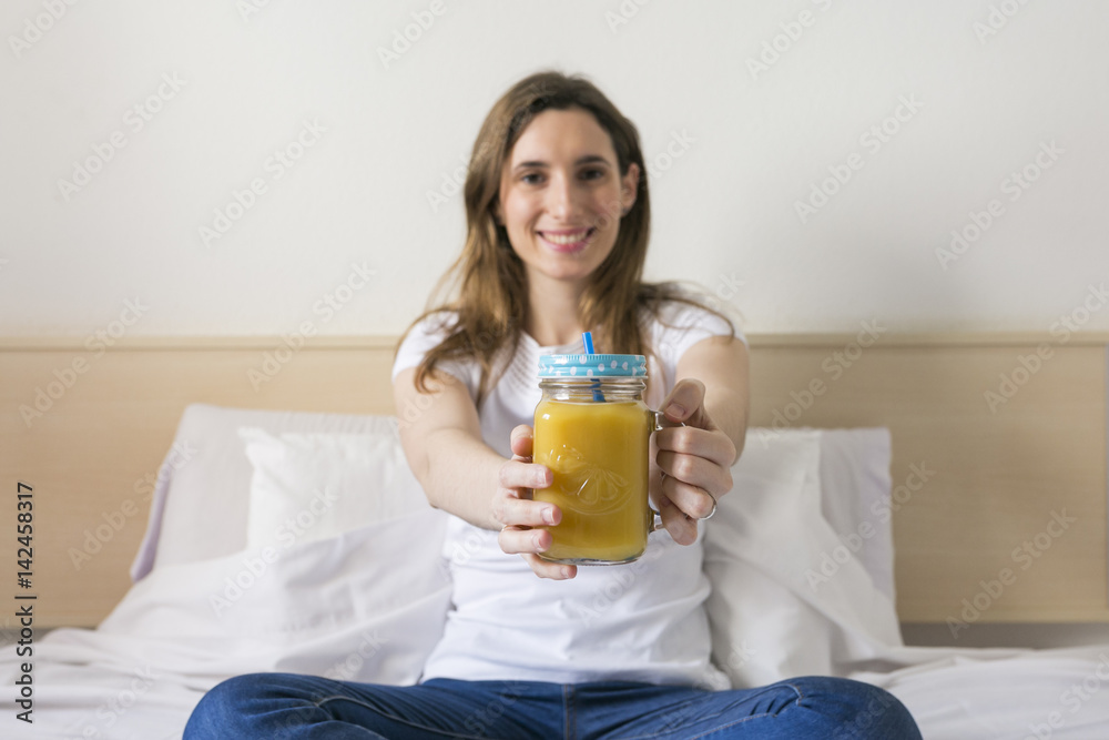 beautiful young woman enjoying a healthy orange juice at home and smiling. Daytime. Lifestyle beautiful young woman enjoying a healthy orange juice at home and smiling. Daytime. Lifestyle