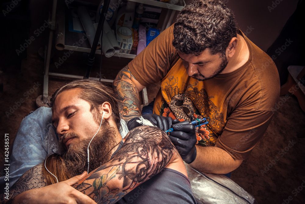 Obraz premium Tattoo artist makes cool tattoo in studio
