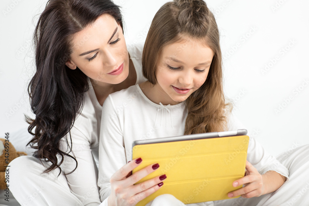 Beautiful mother and daughter using digital tablet together Beautiful mother and daughter using digital tablet together