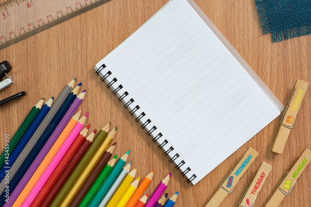 Blank notebook ,colorful pensils and Stapler on wooden desk for any idea on desk work. Blank notebook ,colorful pensils and Stapler on wooden desk for any idea on desk work.