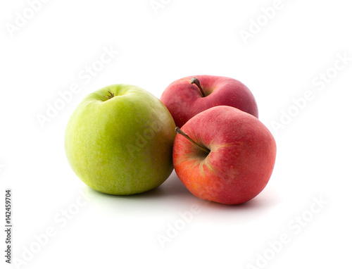 Two red and one green ripe apples on a white background..