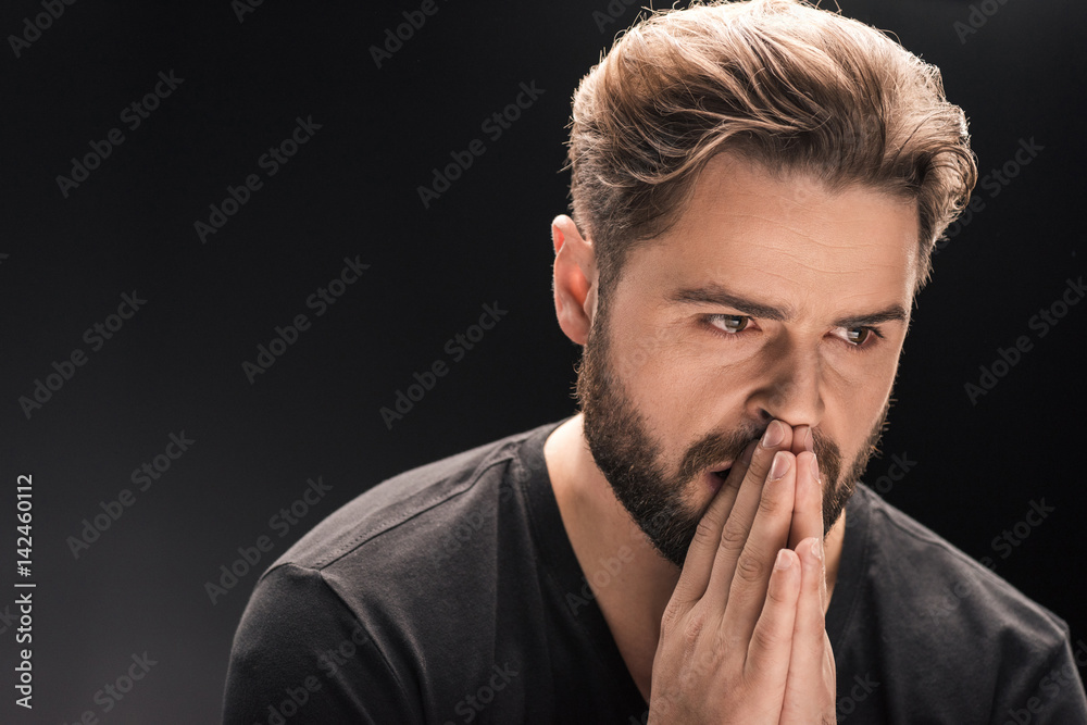 upset bearded handsome man on black with copy space