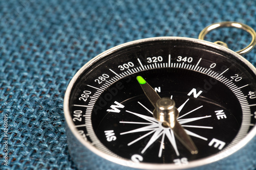 Perspective view of Magnetic Compass on blue sackcloth background.