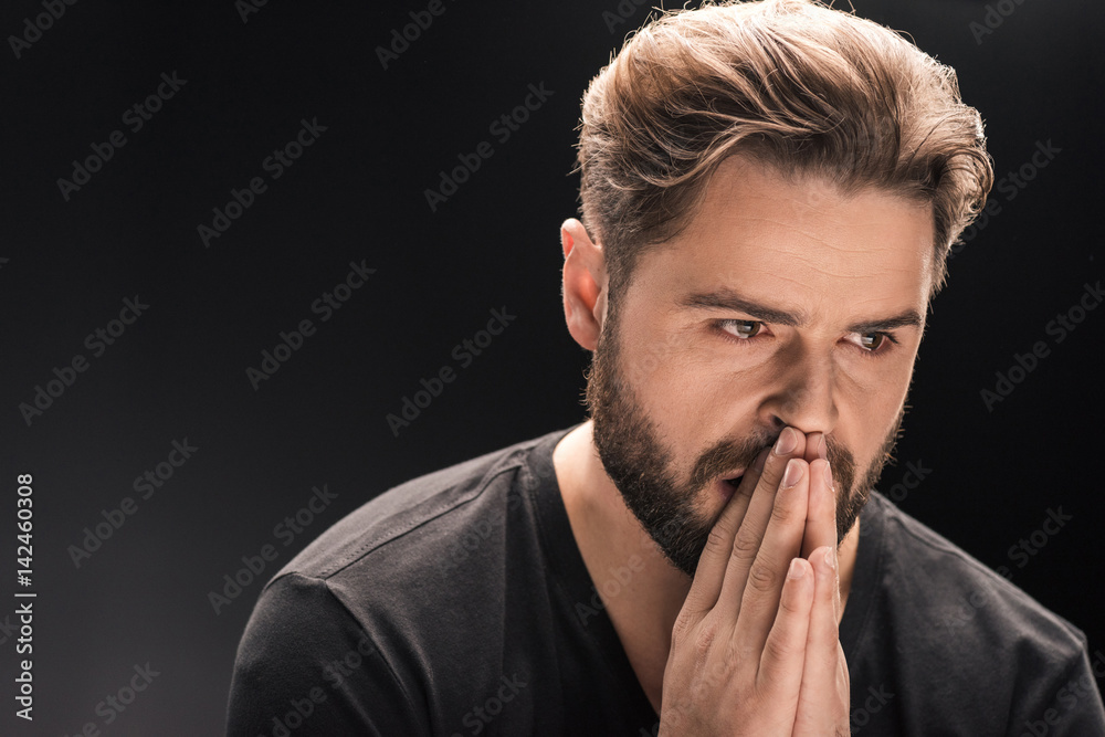 upset bearded handsome man on black with copy space upset bearded handsome man on black with copy space