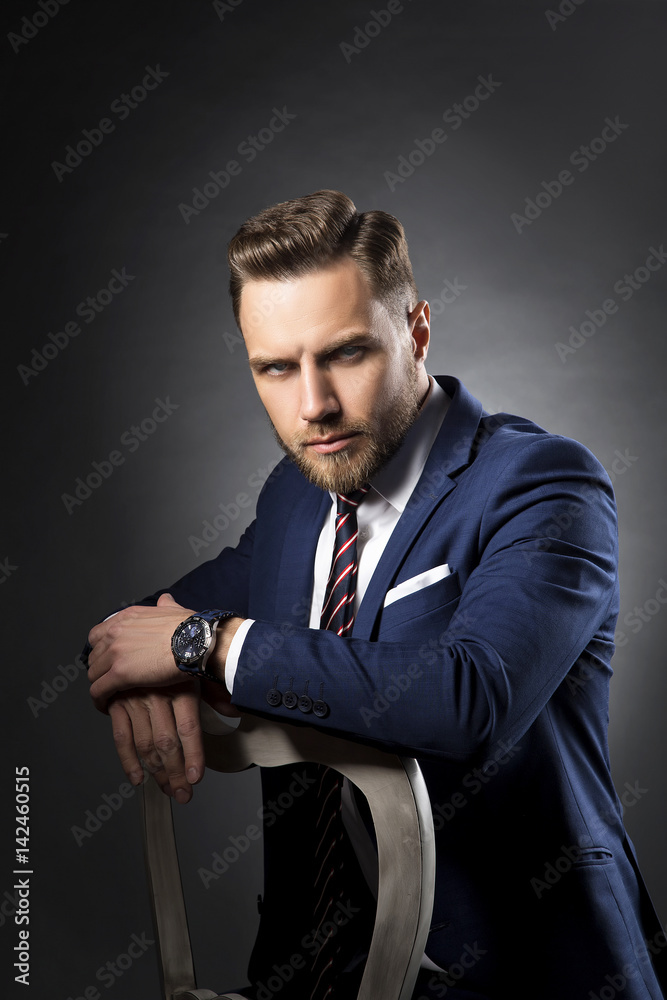 Fashion portrait of man sitting on chair. Hair style, blue eyes, wearing  watch tie and suit. Stock Photo | Adobe Stock