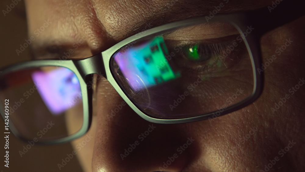 Obraz premium Refleksja w okularach człowieka: patrząc na stronę internetową