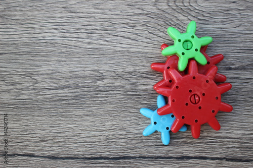 Colorful Plastic Cogs / Gears on a Wood Background
