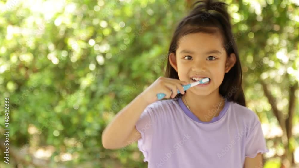 Cute Asian Little Girl Brushing Teeth after meal Cute Asian Little Girl Brushing Teeth after meal
