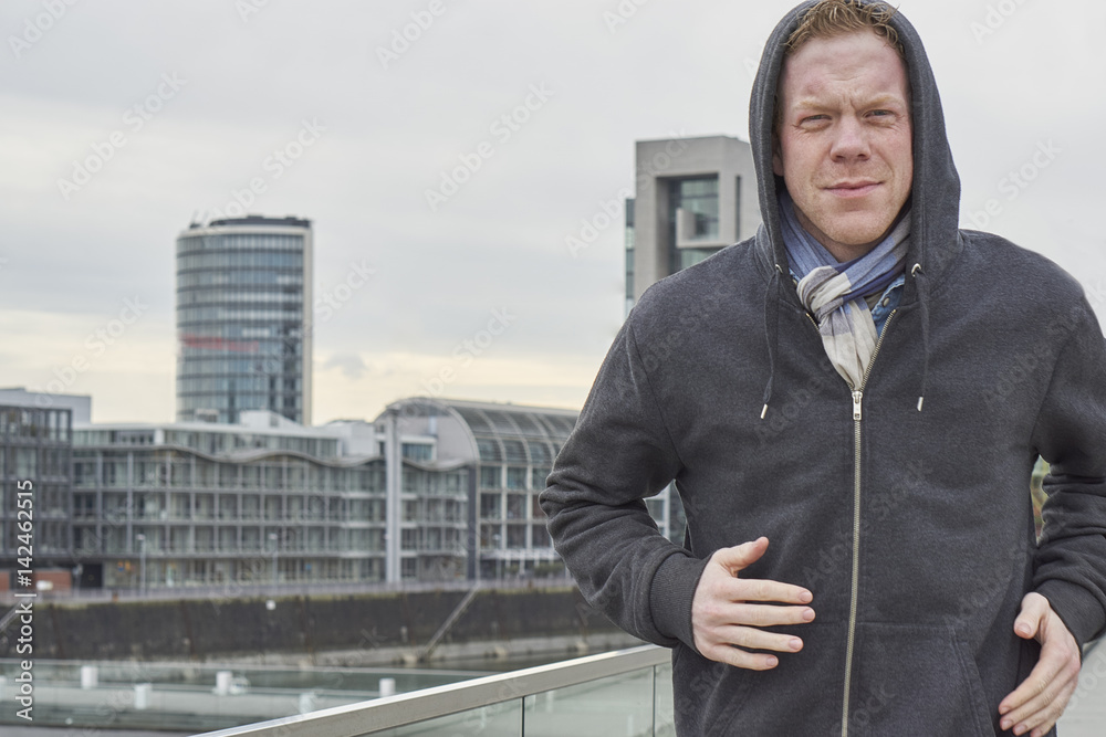 Mann mit Kapuze läuft durch Stadt Mann mit Kapuze läuft durch Stadt