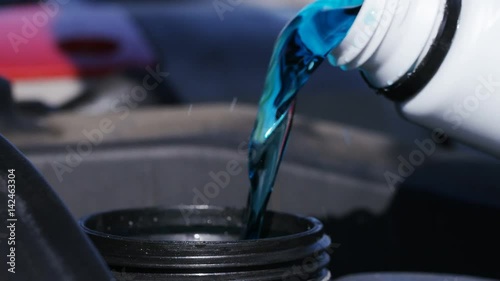4K Close up of engine coolant being poured into a car photo