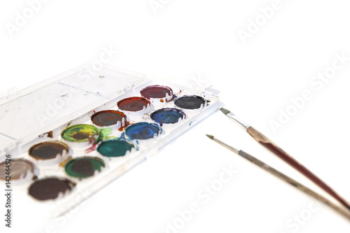 palette with paints and brushes isolated on white