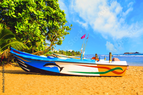 Bright boats on the tropical beach of Bentota, Sri Lanka on a sunny day photo