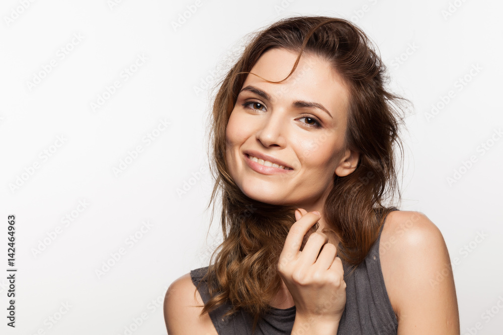 Close-up portrait of a cute stylish smiling young woman with hand near face on white background Close-up portrait of a cute stylish smiling young woman with hand near face on white background