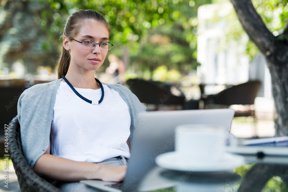 Waist-up portrait of elegant-looking financial manager enjoying sunny spring day in outdoor cafe while preparing annual accounting reports Waist-up portrait of elegant-looking financial manager enjoying sunny spring day in outdoor cafe while preparing annual accounting reports