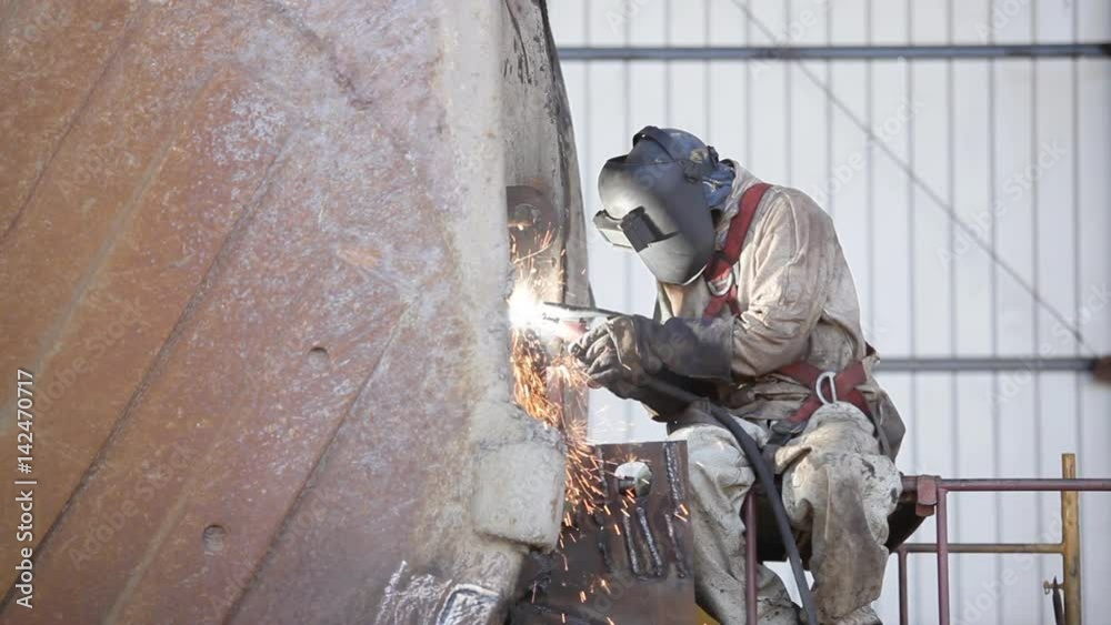 Welder repairing heavy equipment for the mining industry Welder repairing heavy equipment for the mining industry