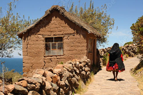 Unrecognizable local woman passing by, in Taquile Island, Titicaca Lake, Peru photo