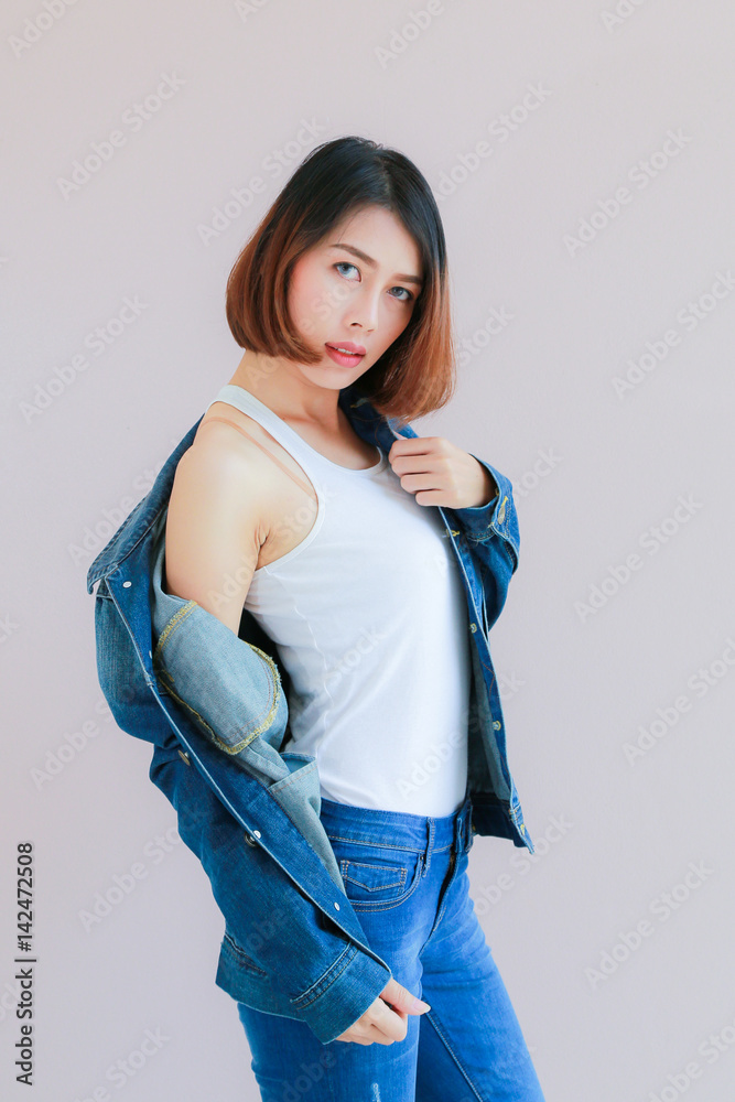 Asian woman casual outfits standing in jeans and blue denim shirt, women  brown hair and short hair, smiling and wearing jeans jacket, beauty and  fashion Jeans concept, space wall background Stock Photo