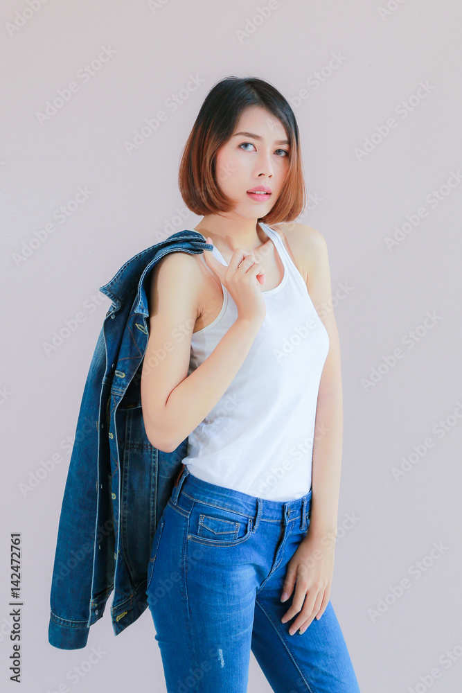 Asian woman casual outfits standing in jeans and blue denim shirt, women  brown hair and short hair, smiling and wearing jeans jacket, beauty and  fashion Jeans concept, space wall background Photos