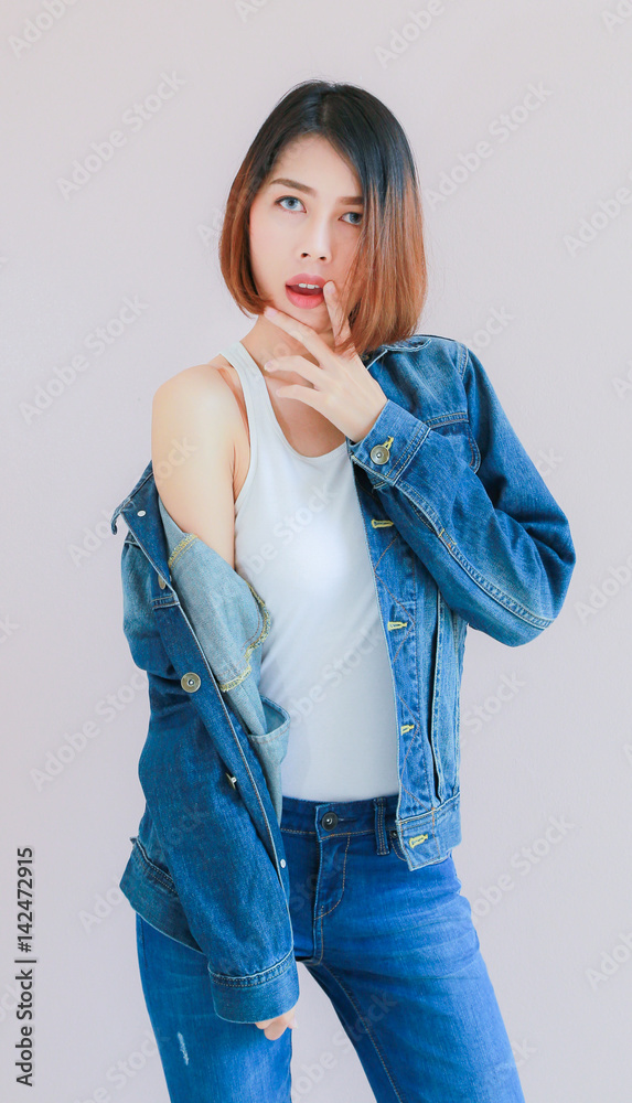 Asian woman casual outfits standing in jeans and blue denim shirt, women  brown hair and short hair, smiling and wearing jeans jacket, beauty and  fashion Jeans concept, space wall background Stock Photo