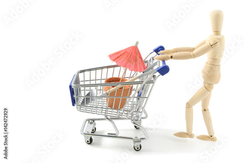 wooden mannequin shopping garden utensils in a shopping cart at white isolated background © lcrms