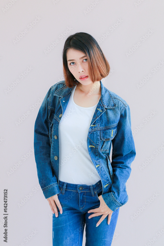 Asian woman casual outfits standing in jeans and blue denim shirt, women  brown hair and short hair, smiling and wearing jeans jacket, beauty and  fashion Jeans concept, space wall background Stock Photo