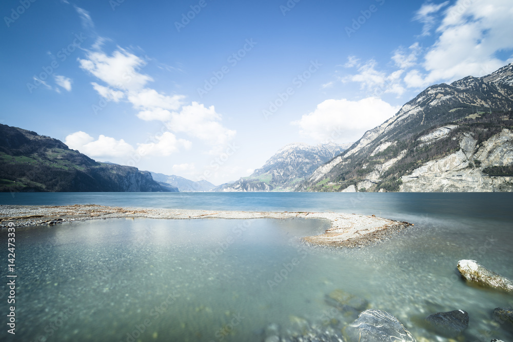 Lake in the canton of Uri. Switzerland. Mountain Lake. Stones on the shore. Long exposure.