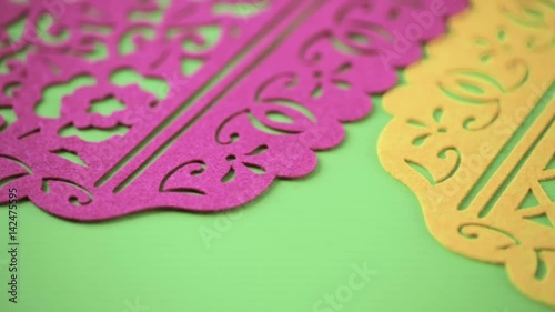 Traditional Mexican papel picado paper banner on a wood background