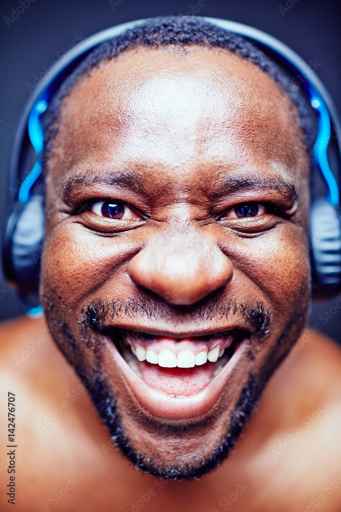 Close-up shot of funny African American music lover looking at camera and  making faces against black background Stock Photo | Adobe Stock
