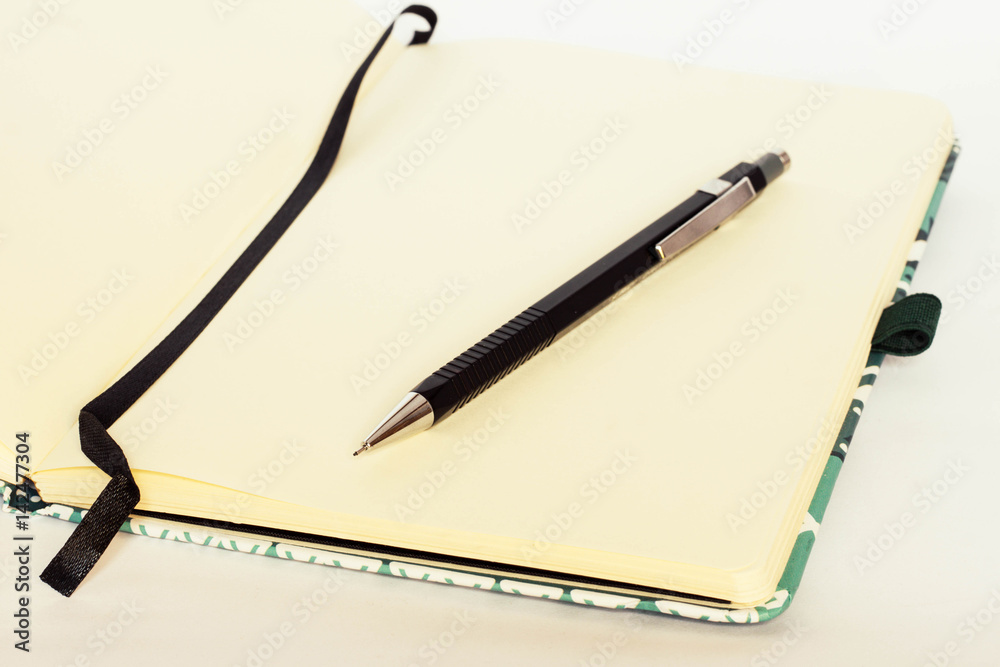 Notebook with bookmark and with blank pages and black pen near on white background