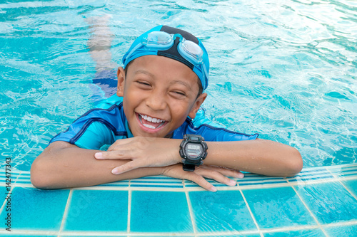 Portrait of a boy smiling in public swimming pool