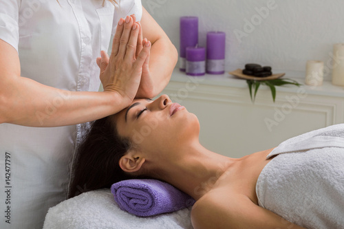 Woman beautician doctor make head massage in spa wellness center