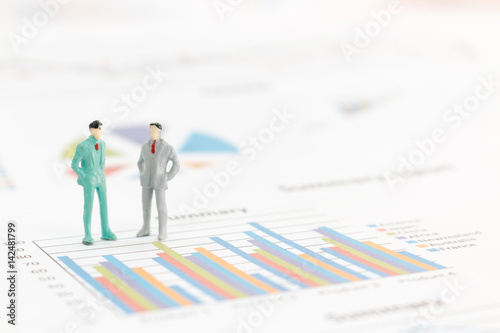 Miniature figures businessman standing on a graph chart
