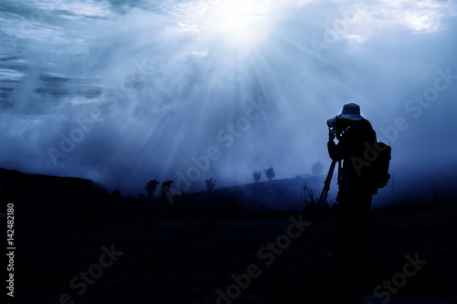 silhouette of photographer shooting sunrise in the morning