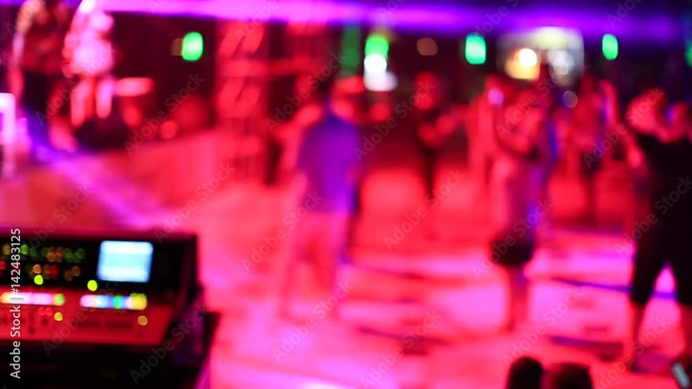 dancing people in front of the dj decks at night club dancing people in front of the dj decks at night club